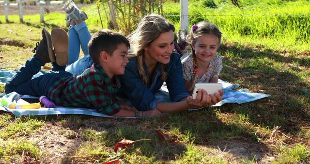 Mother Enjoying Outdoor Picnic with Children Viewing Smartphone - Download Free Stock Images Pikwizard.com