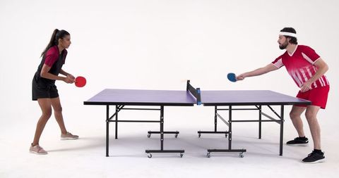 Diverse athletes competing at table tennis in studio setting