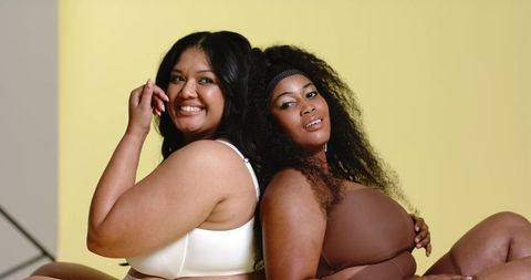 Confident plus-size models posing back-to-back in neutral lingerie for inclusive campaign