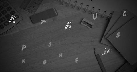 Floating english alphabets with school supplies on wooden surface