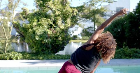 Woman Doing Yoga Stretch in Sunny Garden by Pool - Download Free Stock Images Pikwizard.com