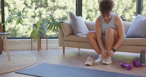 Woman preparing for workout in modern living room with natural light