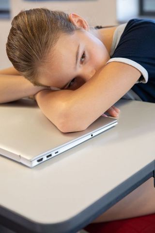 Teenage girl resting during study at classroom desk