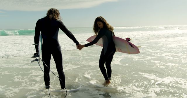 Couple Holding Hands Walking into Ocean with Surfboards - Download Free Stock Images Pikwizard.com