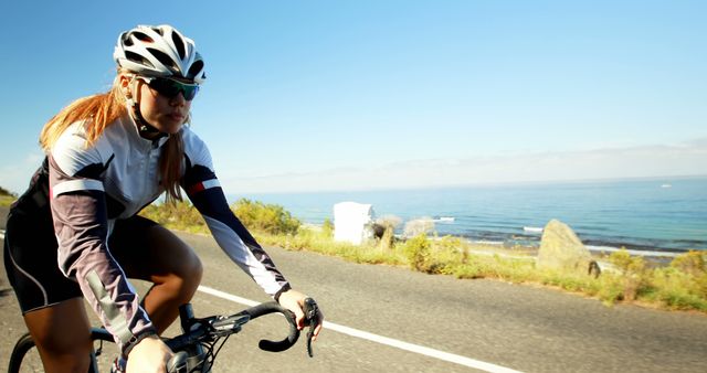 Female Cyclist Riding Along Coastal Road on Sunny Day - Download Free Stock Images Pikwizard.com