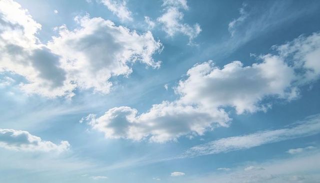 Sunlit Blue Sky with Fluffy Cumulus and Wispy Cirrus Clouds Drifting Overhead