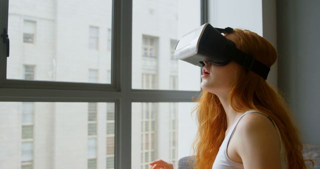 Redheaded Woman Experiencing Virtual Reality Indoors Near Window - Download Free Stock Images Pikwizard.com