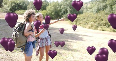 Hikers pointing and navigating sunlit trail using smartphone, backpacks, purple heart overlays