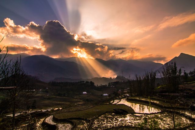 Captivating scenery of sunset casting light over terraced fields in the mountains. Perfect for nature-related content, travel promotions, environmental awareness campaigns, or inspirational backgrounds.