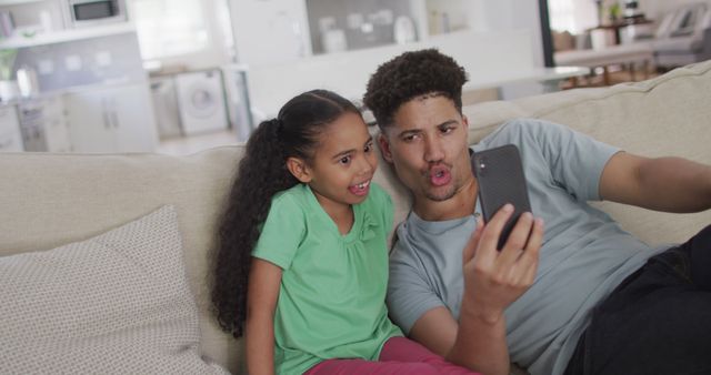 Father and daughter playing with smartphone camera together indoors - Download Free Stock Images Pikwizard.com