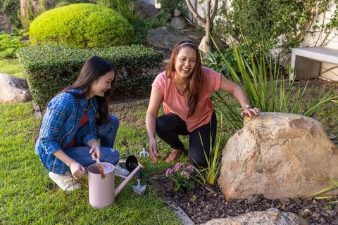 Asian Mother and Daughter Gardening at Home Backyard