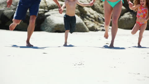 Family Enjoying Day Running on Sandy Beach