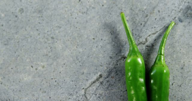 Two Green Chili Peppers on Gray Stone Background - Download Free Stock Images Pikwizard.com