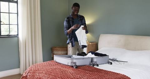 Man Packing Suitcase in Modern Cozy Bedroom