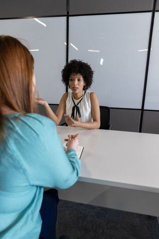 Diverse Colleagues Discuss Strategies in Modern Office Meeting