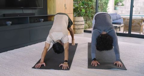 Men Practicing Yoga Indoors by Modern Glass Patio
