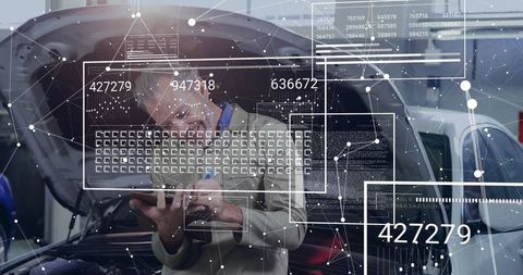 Technician analyzing digital diagnositics on tablet near car