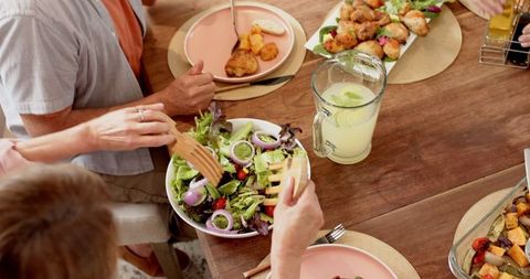 Family enjoying fresh salad shown at cozy dining experience