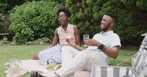Young Couple Enjoying Picnic Outdoors on Sunny Day