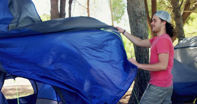 Young Man Setting Up Tent in Forest - Download Free Stock Images Pikwizard.com