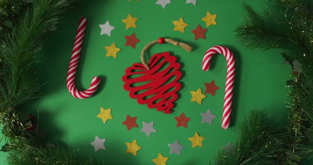 Christmas decorations and candy canes framed with fir tree branches on green background - Download Free Stock Photos Pikwizard.com