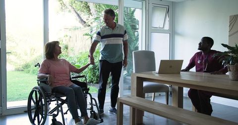 Senior couple with caregiver in bright living room