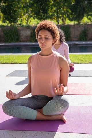Women Practicing Yoga Outdoors Near Pool for Relaxation and Wellness