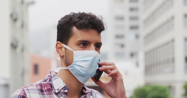 Young Man Wearing Face Mask Talking on Smartphone in City - Download Free Stock Images Pikwizard.com