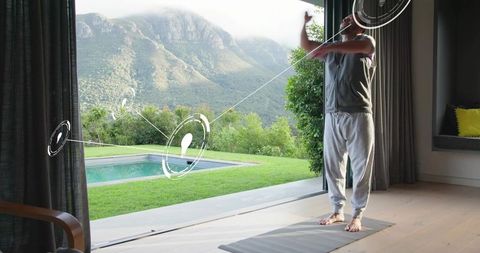 Man stretching by open patio with mountain view and virtual fitness hud interface