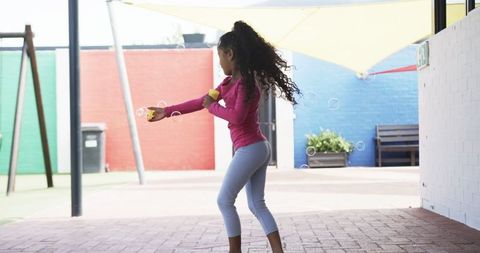 Playful Girl Blowing Bubbles in Schoolyard
