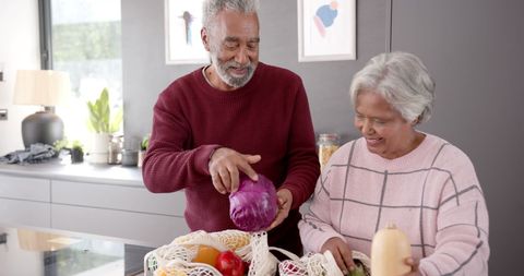 Senior Couple Unpacking Vegetables in Modern Kitchen