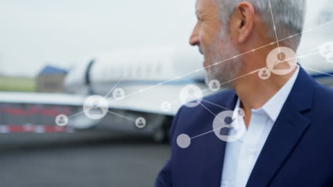Businessman with Networking Icons Overlaid Standing by Private Plane