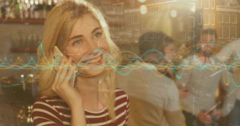 Woman Smiling While Using Smartphone in Trendy Bar Setting