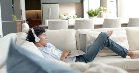 Relaxed Young Man Enjoying Technology While Lounging at Home