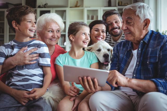 Happy multi-generation family using digital tablet in living room at home