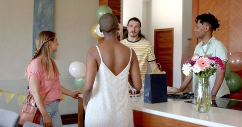 Friends enjoying festive gathering at home wearing casual outfits