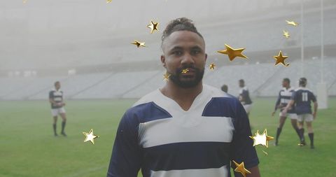 Standing rugby player facing camera wearing navy-and-white jersey with gold stars