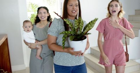 Women and Baby Sharing Gifts in Bright Entryway