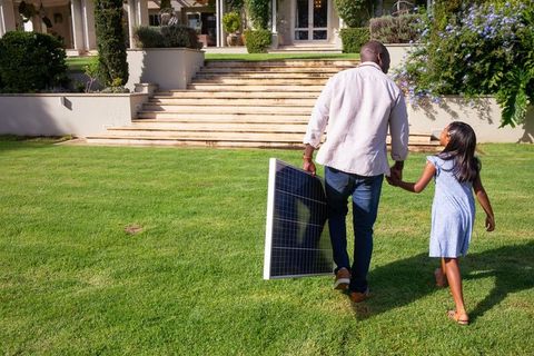 Father and Daughter with Solar Panel Promoting Eco-Friendly Living