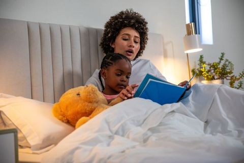 Mother and Daughter Reading in Bed for Bedtime Story Tradition