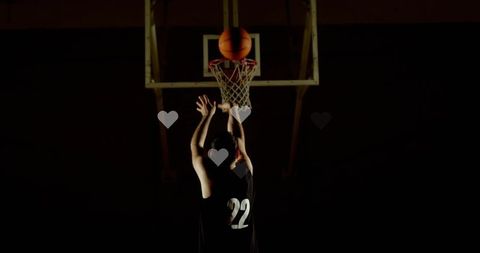 Basketball Player Shooting Exterior in Dimly Lit Gymnasium