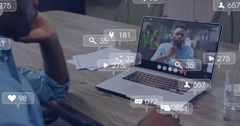 Hybrid team joining virtual meeting on laptop with floating social engagement icons