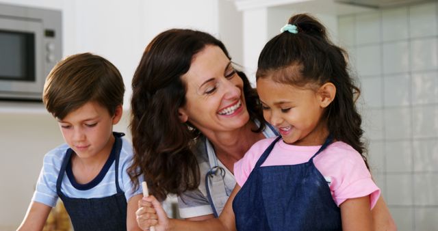 Happy Mother Cooking with Her Two Children in the Kitchen - Download Free Stock Images Pikwizard.com