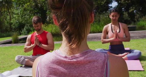 Yoga Class in Park with Diverse Group Practicing Meditation