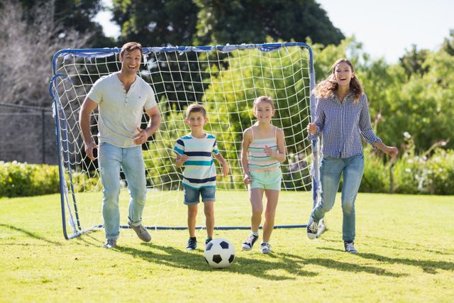Happy family playing football together at the park