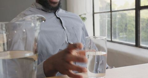 Thoughtful Man in Office Taking Hydration Break with Glass of Water - Download Free Stock Images Pikwizard.com