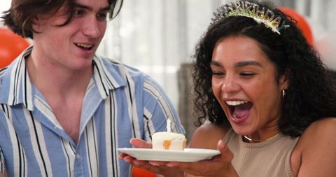 Multiracial couple celebrating birthday with cupcake
