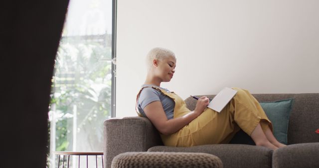 Young Woman Relaxing on Couch Writing in Journal - Download Free Stock Images Pikwizard.com