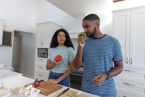 Diverse Couple Preparing Fresh Ingredients in Modern Kitchen