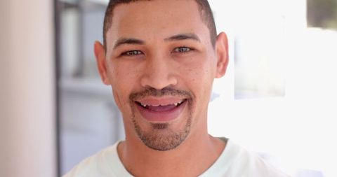 Smiling man in modern home with natural lighting indoors